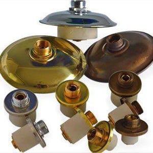 Puede incluir: Una colección de varios componentes metálicos para luminarias. Los componentes incluyen pantallas redondas y metálicas en acabados de latón, cobre y plata, junto con casquillos cilíndricos y herrajes de montaje.