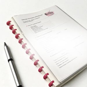 May include: A medical record binder with pink spiral binding and a silver pen. The binder contains a document titled "Vascular Occlusion (VO) Record" with the Hollie logo. The document includes sections for client and treatment details.