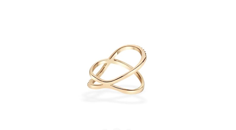 Puede incluir: Un anillo dorado con un dise&ntilde;o abierto e entrelazado. El anillo presenta una serie de peque&ntilde;os adornos brillantes a lo largo de una de las bandas curvas. El dise&ntilde;o del anillo es moderno y elegante, adecuado para el uso diario o ocasiones especiales.