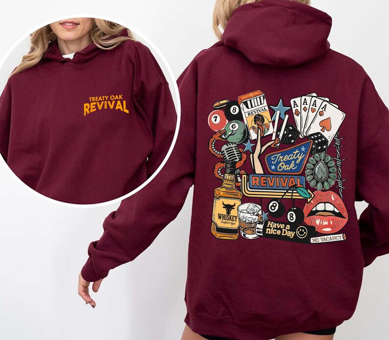Op de afbeelding: Bordeaux hoodie met de tekst "Treaty Oak Revival" op de voorkant en een afbeelding op de achterkant met speelkaarten, een whiskyfles en lippen. De afbeelding op de achterkant bevat de tekst "Have a nice day" en "No Vacancy".