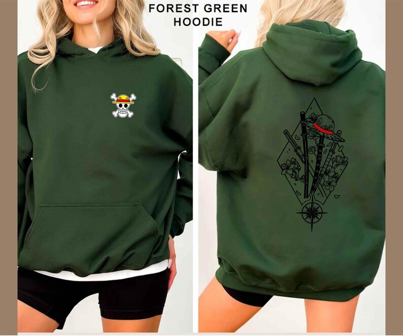 May include: Forest green hoodie with a front pocket and a hood. The front features a small skull and crossbones logo with a yellow hat. The back displays a black graphic of a hat, swords, and flowers within a diamond shape.