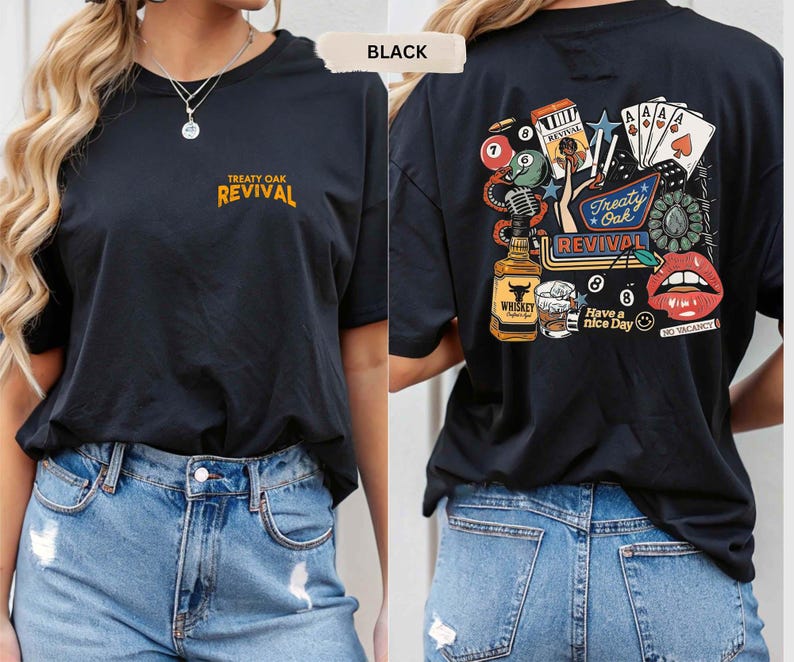 Op de afbeelding: Zwart T-shirt met korte mouwen met de tekst "Treaty Oak Revival" in goud op de voorkant. De achterkant van het shirt heeft een kleurrijke afbeelding met een fles whisky, speelkaarten en de woorden "Have a nice day."