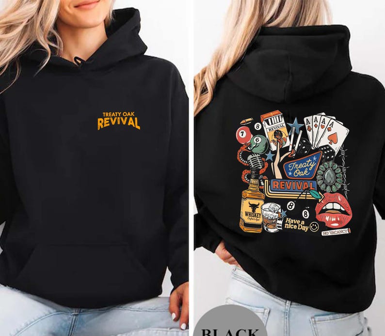 Op de afbeelding: Zwarte hoodie met een voorzak en een capuchon met trekkoord. De voorkant heeft de tekst "TREATY OAK REVIVAL" in oranje. De achterkant heeft een kleurrijke afbeelding met speelkaarten, een fles whisky en de tekst "Treaty Oak Revival."
