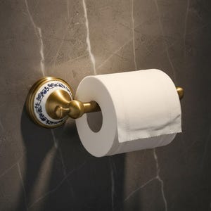 Peut inclure: Un porte-papier toilette en laiton et céramique avec un rouleau de papier toilette blanc. Le support présente un disque décoratif en céramique avec des motifs floraux bleus et une tige en laiton pour maintenir le rouleau de papier.