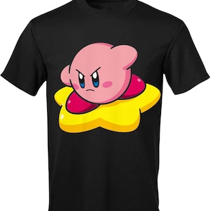 Könnte beinhalten: Schwarzes T-Shirt mit einer pinkfarbenen und gelben Comicfigur von Kirby, einem Videospielcharakter, mit einem wütenden Ausdruck.