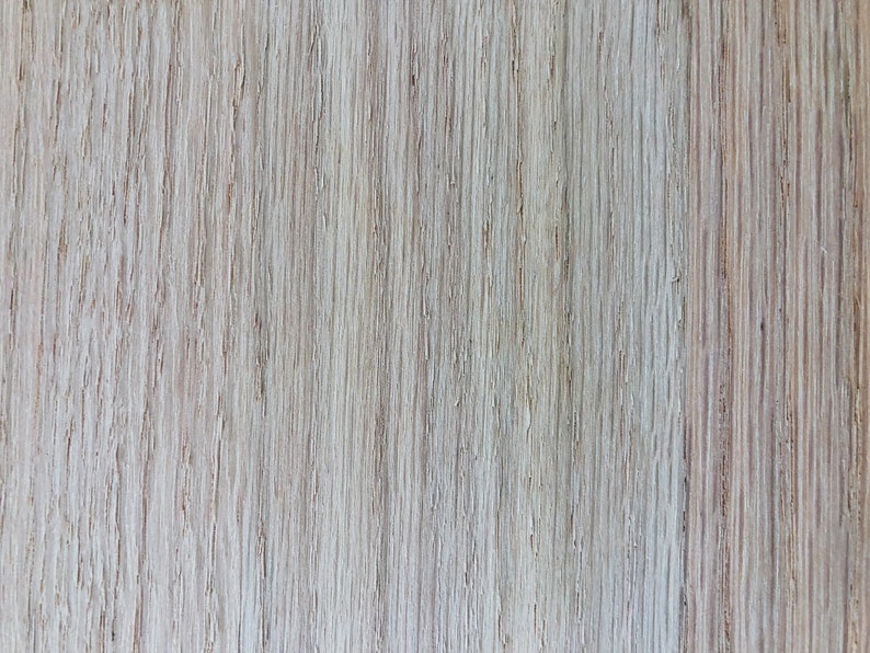 May include: Close-up of a light brown wood grain surface with a vertical pattern.
