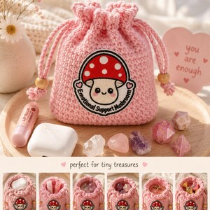 Könnte beinhalten: Ein rosa gehäkelter Kordelzugbeutel mit einem Pilzaufnäher mit der Aufschrift "Emotional Support Mushroom". Die Tasche wird mit Kristallen, Würfeln, Lippenbalsam und Airpods präsentiert. Das Bild zeigt auch den Text "you are enough" auf einem rosa Herzen.