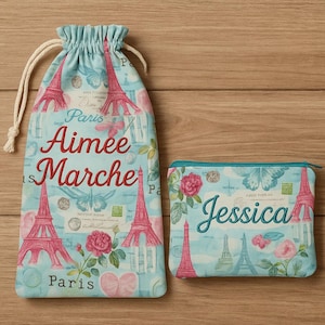 May include: A drawstring bag and a zippered pouch featuring a light blue background with pink Eiffel Towers, butterflies, and floral designs. The bag has the text "Aimee Marche" and the pouch has the name "Jessica".
