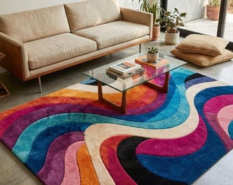 May include: A colorful, wavy area rug with a retro design. The rug features a vibrant palette of orange, pink, purple, blue, and cream. A light-colored sofa and coffee table with books are in the background.
