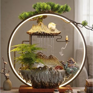 Puede incluir: Fuente de agua decorativa para interiores con un diseño sereno. La fuente presenta un marco circular con luz integrada, un paisaje en miniatura con una cascada, un pequeño árbol y una estatua de Buda sonriente. La base es de madera.