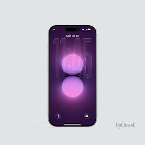 May include: A smartphone with a purple screen displaying the time 11:45 and the date, Monday, February 23. The screen features two glowing, spherical shapes. The phone has a black border and is set against a light gray background.