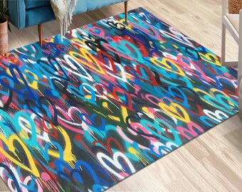 Puede incluir: Una alfombra rectangular con un patrón denso y superpuesto de contornos de corazones dibujados a mano en tonos vibrantes de azul, amarillo, rosa, rojo y blanco, sobre un fondo gris oscuro con un efecto texturizado de salpicaduras de pintura.