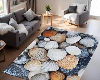 May include: A rectangular area rug featuring a detailed seashell design. The rug showcases a variety of seashells in shades of white, tan, orange, and gray, creating a textured, realistic appearance. The rug is placed on a wooden floor in a living room setting.