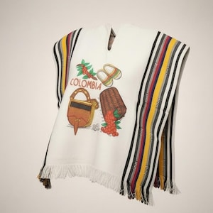 May include: White poncho with colorful striped accents and fringe. The front features embroidered images of a bag, basket, coffee beans, and the word "COLOMBIA". The poncho has a V-neck.