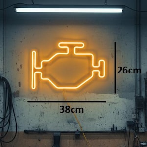 Könnte beinhalten: Ein Neonzeichen in Form eines Motors, 38 cm breit und 26 cm hoch, leuchtet in warmem Orange an einer Garagenwand. Im Hintergrund arbeitet ein Mechaniker in einer Werkstatt voller Werkzeuge.