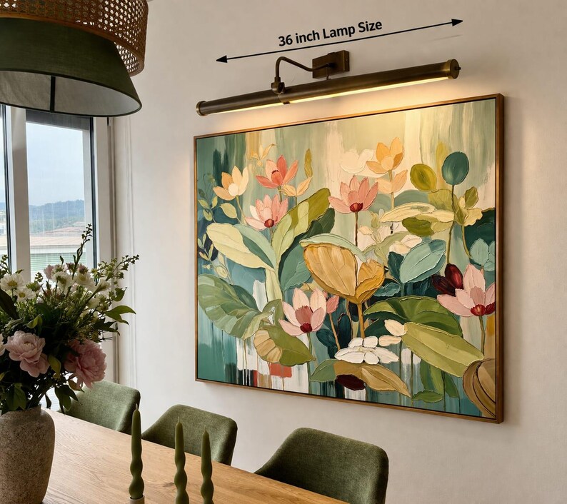 May include: A framed floral painting with a 91 cm lamp above it. The artwork features pink, yellow, and white flowers with green leaves. The lamp has a bronze finish and is mounted on the wall. The painting is in a wooden frame.