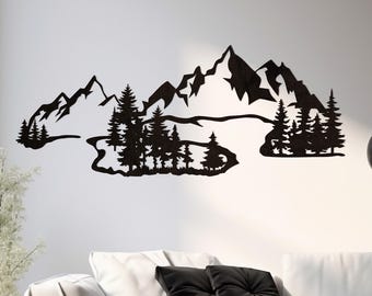 May include: Black metal wall art depicting a mountain range with trees and a river. The artwork is mounted on a white wall above a white sofa with black pillows. A black rug and coffee table complete the modern living room setting.