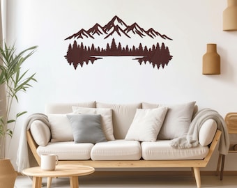 May include: A brown metal wall art piece depicting a mountain range, trees, and a lake reflection. The artwork is mounted on a white wall above a light-colored sofa with neutral-toned pillows. A round wooden coffee table and decorative items complete the scene.