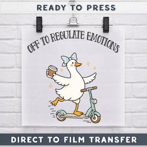 May include: A white print featuring a cartoon duck riding a scooter and holding a coffee cup. The duck wears a blue bow and the text "OFF TO REGULATE EMOTIONS" is above the duck. The words "READY TO PRESS" and "DIRECT TO FILM TRANSFER" are also present.