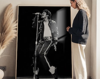 May include: A large rectangular framed wall art print featuring a black and white photograph of a performer singing into a microphone while wearing a jacket with metallic embellishments, a white shirt, and dark trousers with a light side stripe.
