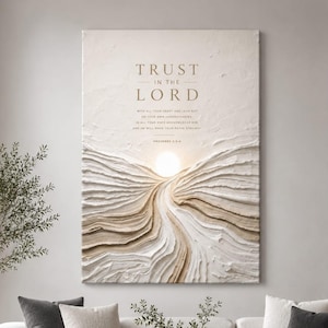 May include: A textured wall art piece with the words "TRUST IN THE LORD" in gold lettering. The artwork features a layered, abstract design in shades of white and beige, with a bright circular element resembling the sun.