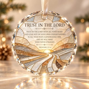 May include: A circular crystal ornament featuring a stained-glass style landscape with a winding road and a sun. The text reads: TRUST IN THE LORD. TRUST IN THE LORD WITH ALL YOUR HEART AND LEAN NOT ON YOUR OWN UNDERSTANDING; IN ALL YOUR WAYS ACKNOWLEDGE HIM, AND HE WILL MAKE YOUR PATHS STRAIGHT. PROVERBS 3:5-6.