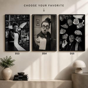 May include: Three black and white framed wall art prints labelled D13, D14, and D15. D13 shows a person holding a toilet paper roll. D14 shows a person with glasses holding a toilet paper roll. D15 shows a group of people looking down in a circle.