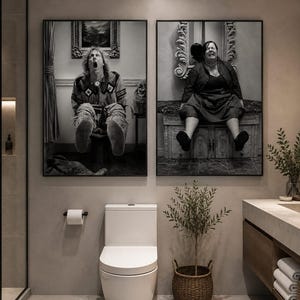 May include: Two rectangular black and white wall art prints displayed side by side in a bathroom. The left print shows a person with long hair sitting on a toilet with their mouth open. The right print shows a person sitting on a decorative vanity.