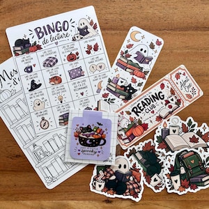 May include: A collection of autumn-themed stationery featuring a reading bingo card, a bookmark with a ghost and cat, a ticket-shaped reading club bookmark, and several die-cut stickers depicting books, pumpkins, ghosts, and cats with fall leaves.