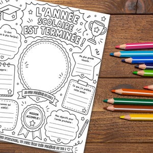 May include: A black and white printable school year end activity sheet with French text including L'ANNÉE SCOLAIRE EST TERMINÉE, featuring a central circle, a trophy, a graduation cap, and various writing prompts, accompanied by several colored pencils.