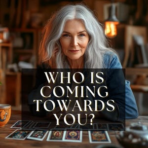 Puede incluir: Una mujer mayor con largo cabello gris mira al espectador. Un rectángulo negro frente a ella dice "WHO IS COMING TOWARDS YOU?" Las cartas del tarot están dispuestas sobre una mesa de madera. Una taza y una tetera también están sobre la mesa.