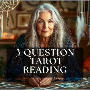 Può includere: Una donna con lunghi capelli grigi è seduta a un tavolo di legno con carte dei tarocchi. Il testo "3 QUESTION TAROT READING" è sovrapposto all'immagine. Acchiappasogni e candele sono sullo sfondo, creando un'atmosfera mistica.