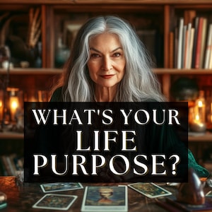 Puede incluir: Una mujer mayor con largo cabello gris mira directamente al espectador. La imagen presenta el texto "WHAT'S YOUR LIFE PURPOSE?" sobre un fondo negro. Cartas del tarot y libros están sobre la mesa.