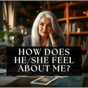 Pode incluir: Uma mulher mais velha com cabelos longos e brancos e um blazer cinza está sentada em uma mesa com cartas de tarô. Uma placa preta na frente dela diz "HOW DOES HE/SHE FEEL ABOUT ME?" Um laptop e estantes estão ao fundo.