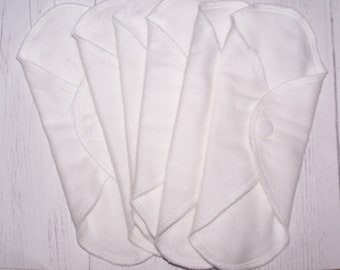 May include: Five white reusable cloth menstrual pads with a snap closure.