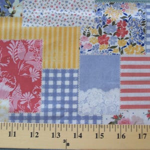 May include: A patchwork fabric with various patterns, including floral, gingham, and striped designs. The colors include red, yellow, blue, and white. The fabric is measured with a ruler in inches.
