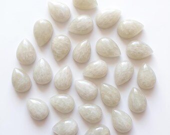 May include: A collection of twenty-four teardrop-shaped cabochons with a smooth, polished surface. Each piece features a translucent, milky white appearance with subtle internal cloud-like textures and a soft, pearlescent sheen throughout.