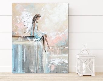 May include: An abstract painting of an angel in a light blue dress with white wings, seated on a ledge. The artwork features a soft color palette of beige, pink, and blue. The painting is displayed on a wooden surface.