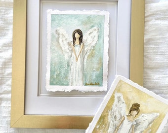 May include: Two watercolor paintings of angels with white wings and white dresses. The angel on the left has a blue and green background, while the angel on the right has a yellow and brown background. Both paintings are signed "Christie Bell".