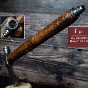 May include: A handcrafted axe with a wooden handle and a metal head. The axe is designed as a pipe, with the text "Pipe" and "You can smoke through the axe" visible.