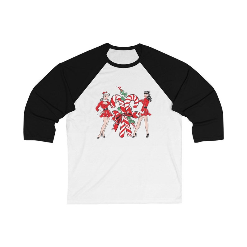 May include: A white and black baseball tee shirt with a Christmas-themed design featuring two women in red dresses standing next to a large candy cane.