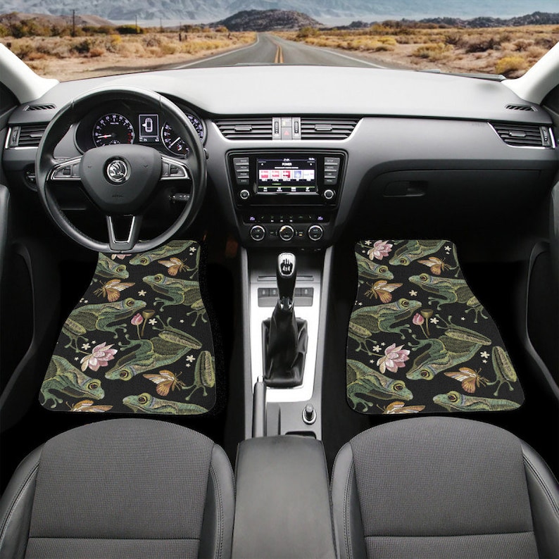 Puede incluir: Alfombrillas de coche negras con un patr&oacute;n de rana verde y flores.