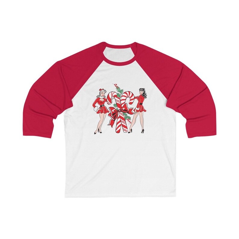 May include: A white and red baseball tee shirt with a Christmas-themed design featuring two women in red dresses standing next to a large candy cane.