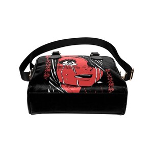 May include: Black shoulder bag featuring a red illustration of a crying face with white hair. The bag has a black strap and handles, with gold-colored hardware. Japanese text is printed on the side of the bag.