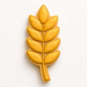 May include: A wheat-shaped cookie cutter. The cookie cutter is a light tan colour with a yellow-orange wheat design. The cookie cutter is on a white background. The wheat design is in the shape of a wheat stalk.