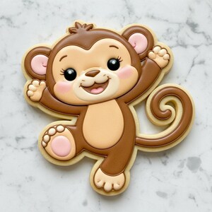 Könnte beinhalten: Ein affenförmiger Keks, verziert mit braunem, beigem und rosa Zuckerguss. Der Keks zeigt einen lächelnden Affen mit großen schwarzen Augen, rosa Wangen und einem lockigen Schwanz. Der Keks ist mit detailliertem Zuckerguss verziert.