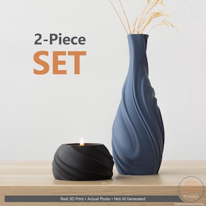 May include: A two-piece set comprising a black candle holder with a lit candle and a blue vase with a spiral design. The vase contains dried ornamental grass. The image displays the text "2-Piece SET".