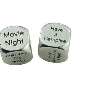May include: Two silver dice with different activities printed on each side. One die has "Movie Night", "Cook for Each Other" and other activities. The other die has "Have a Campfire", "Make a Homemade Pizza" and other activities.