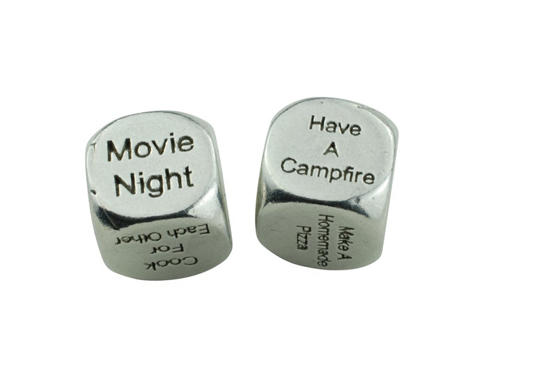 May include: Two silver dice with different activities printed on each side. One die has "Movie Night", "Cook for Each Other" and other activities. The other die has "Have a Campfire", "Make a Homemade Pizza" and other activities.