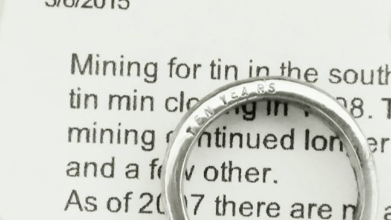 May include: A silver ring with the inscription "Ten Years" on the band.